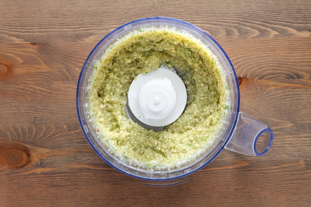 Blitzing ingredients for the pesto in a food processor