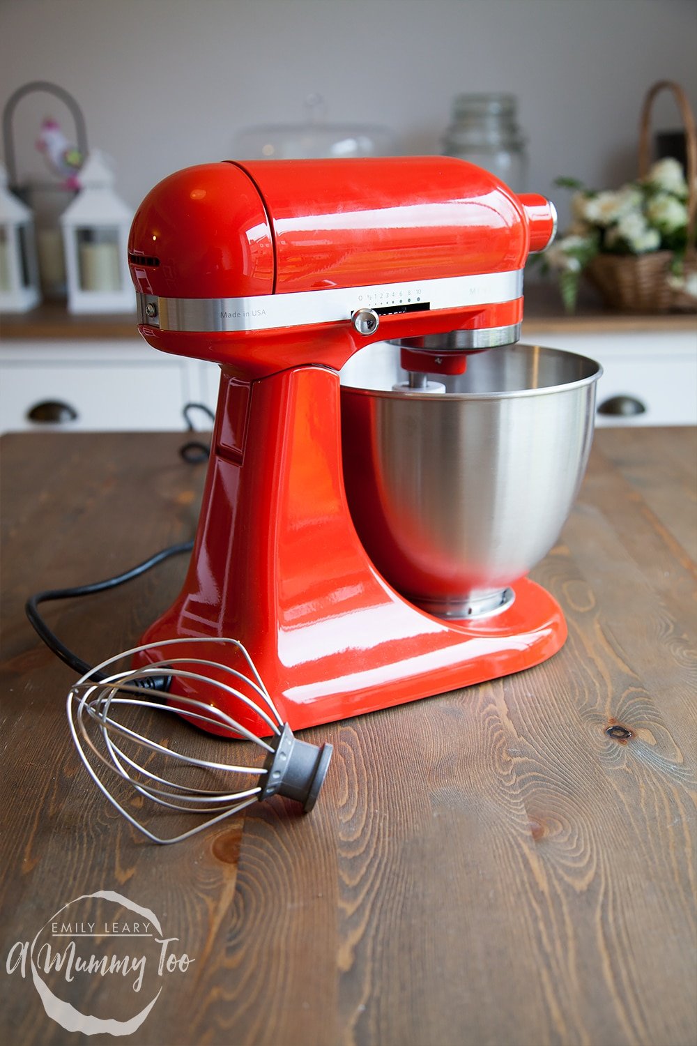 Side on view of the red KitchenAid mini on a wooden tabletop. 