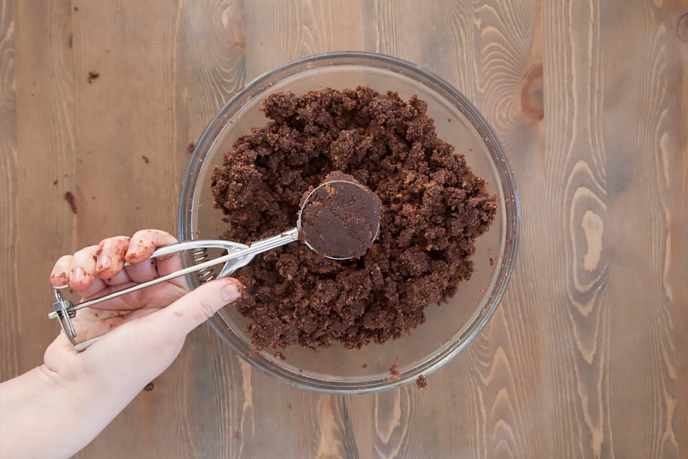 An ice cream scoop is a great way to create perfect balls of the cake mixture. This photo shows the kitty cake pops being created using hte ice cream scoop with the bowl of cake mixture below. 