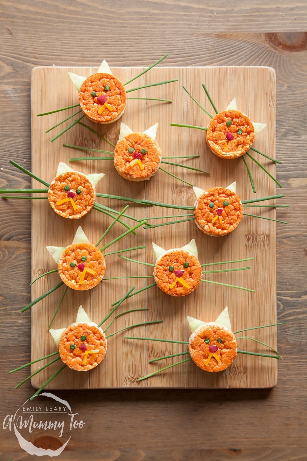 Healthy kitty rice cakes, shown with long whiskers, on top of a chopping board