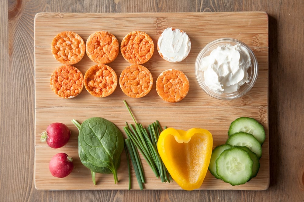 Start by spreading cream cheese on the rice cakes