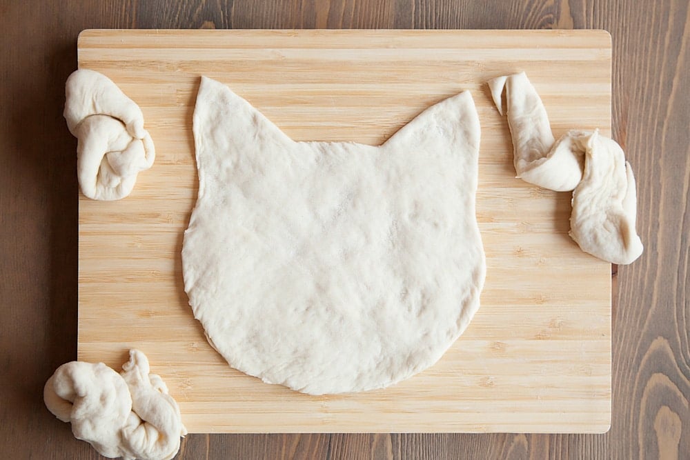 Creating the kitty shaped pizza from fresh dough
