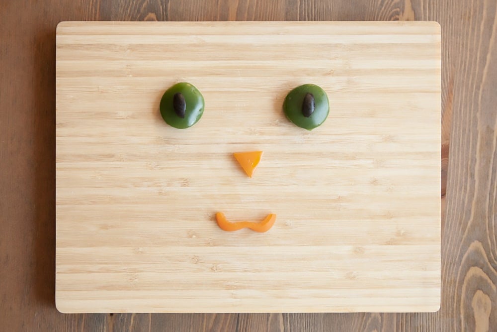 Create the kitty face using your selection of toppings - here we've used vegetables