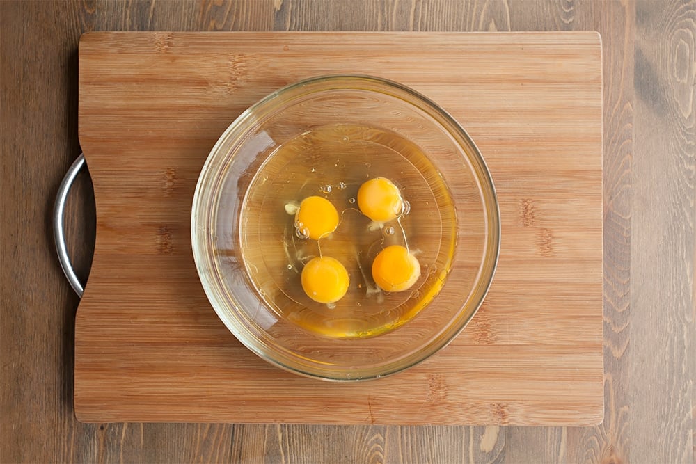 Mixing eggs and oil together in a glass bowl