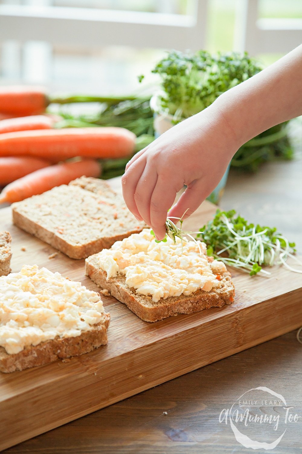 Sprinkling the home-grown cress onto the egg mayo sandwich filling