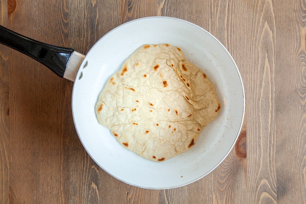Cooking the naan breads in a frying pan