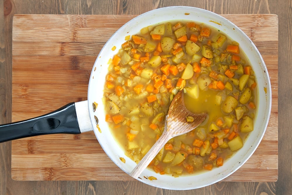 Vegetable stock is added to the frying pan