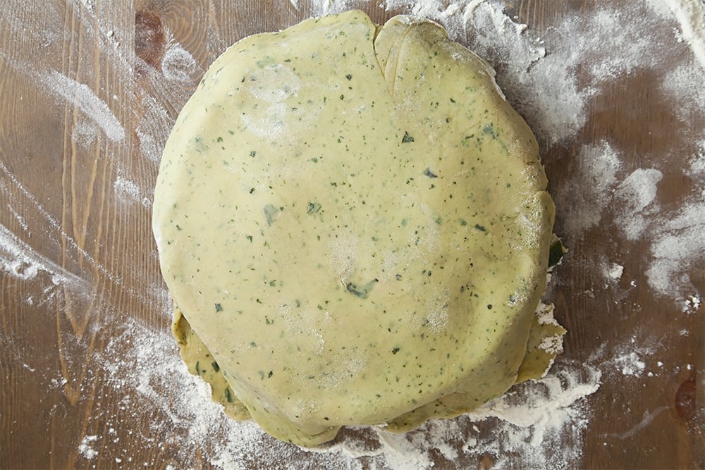 Assembling the layered vegetable pie with basil infused pastry - top with a layer of pastry