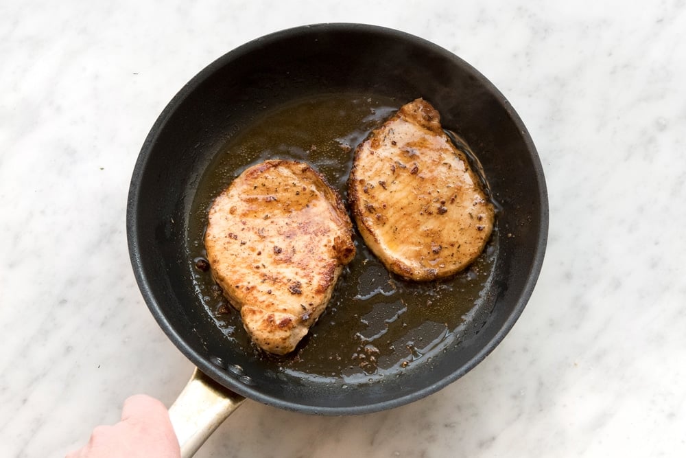 Frying the pork medallions for this tasty Cajun pork with bulgur wheat and garlicky spring greens dish