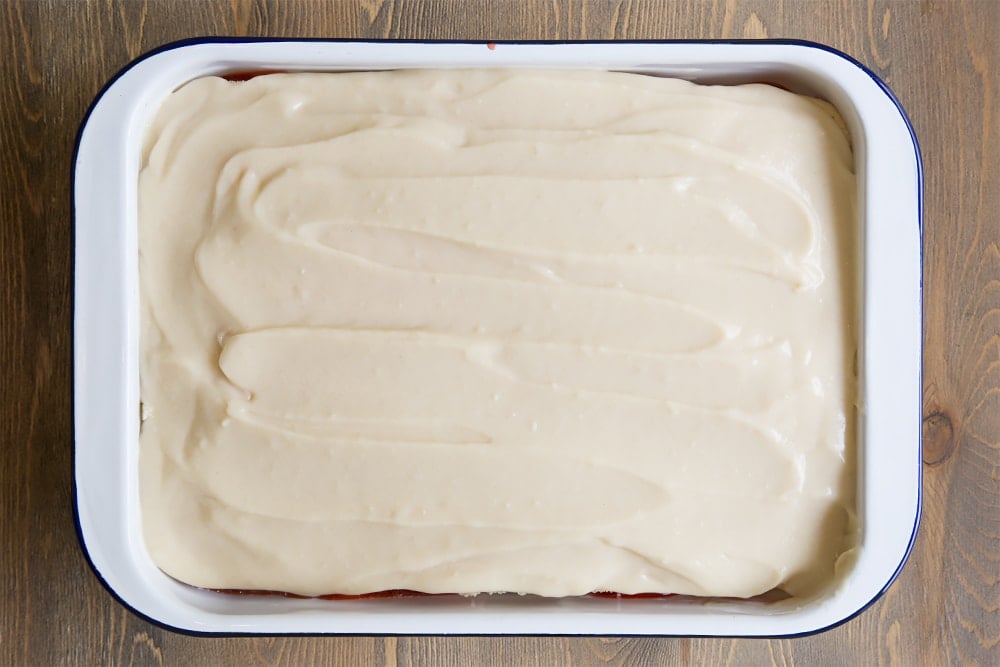 A white metal dish topped with a vanilla sponge layer with a white sauce covered the top.