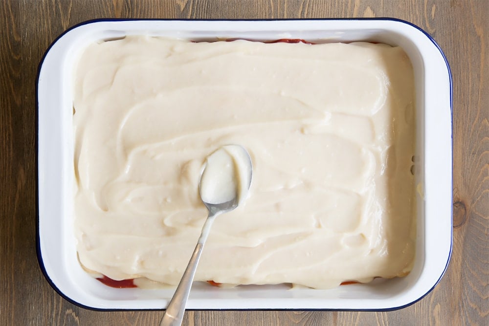 A white metal dish topped with a vanilla sponge layer with a white sauce covered the top.