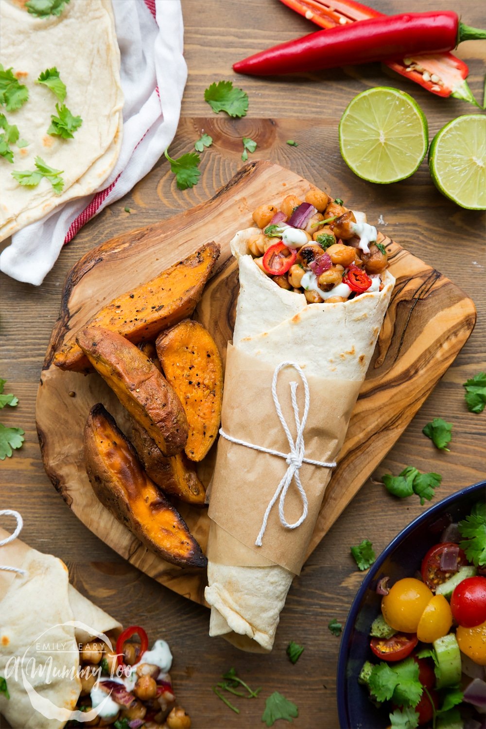 Summer BBQ chickpea wraps, shown at a BBQ ready to eat, alongside potato wedges, tortillas, limes, chilli