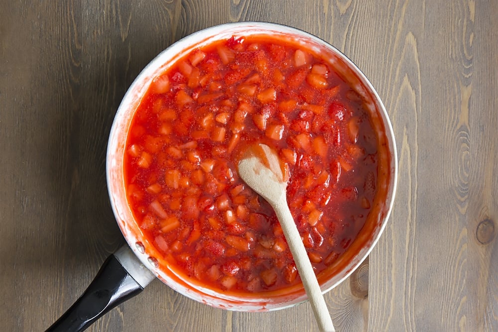 strawberries, cornflour and sugar cooked down to create a jelly like texture in a large saucepan