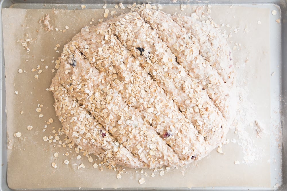 Oats are sprinkled onto the fruit loaf before being baked in the oven