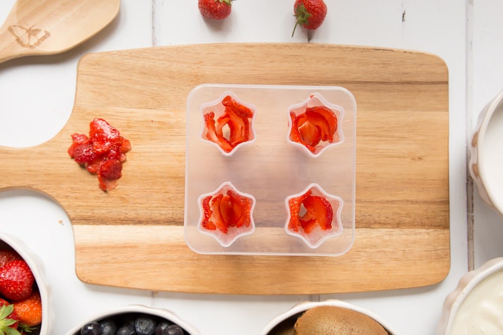 Thinly sliced strawberries shown inside the ice lolly mould