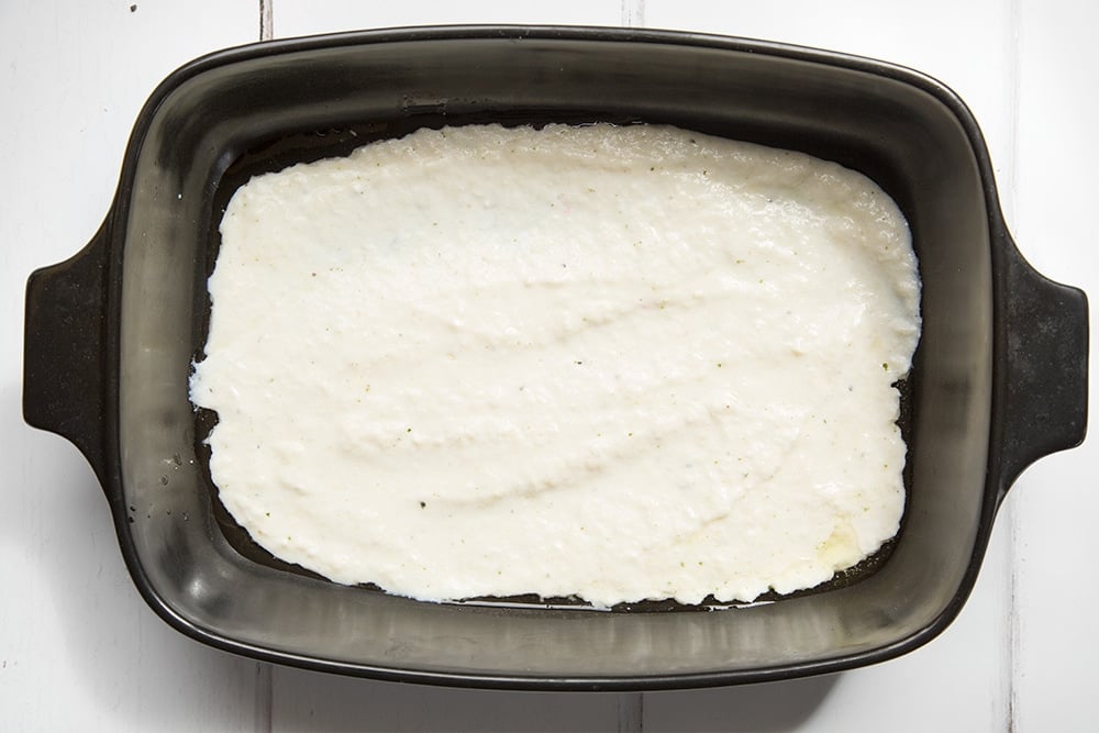 The cheese sauce is poured into a dish ready to bake