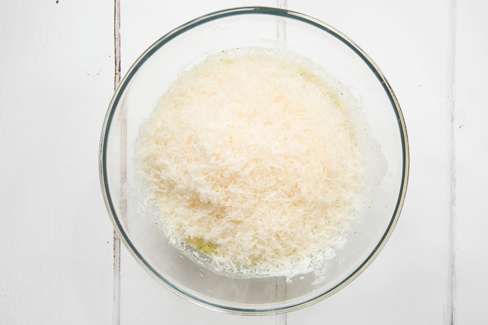 Grated hard cheese is added to the sauce mix