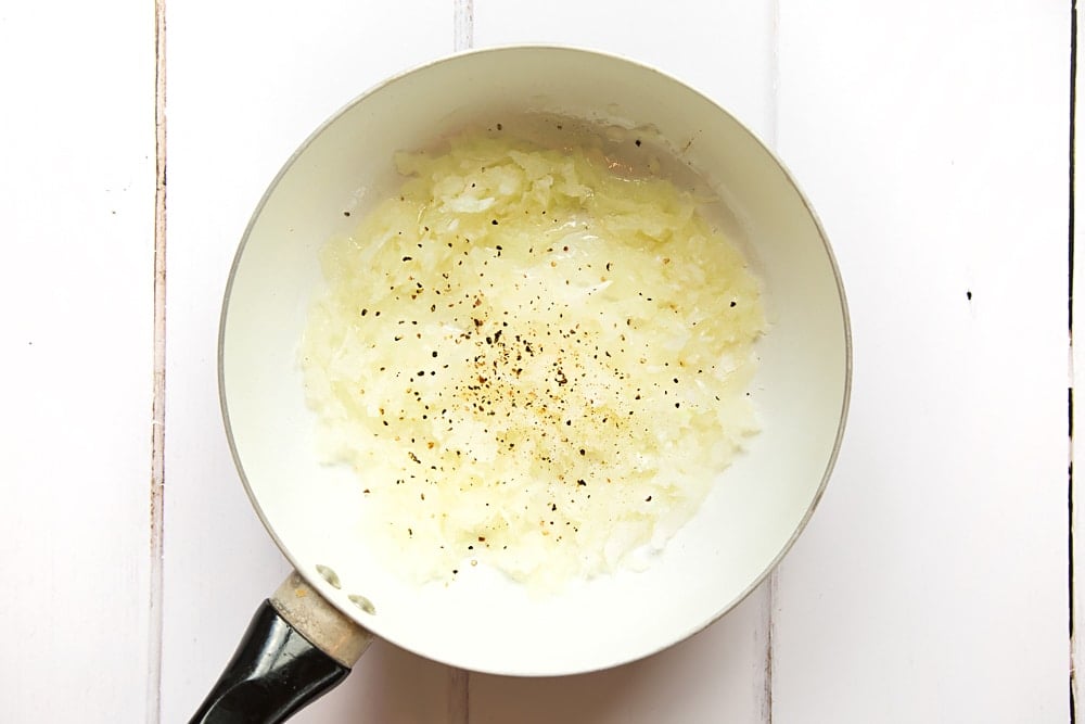 Olive oil and onions are fried in a pan in the first step of this recipe