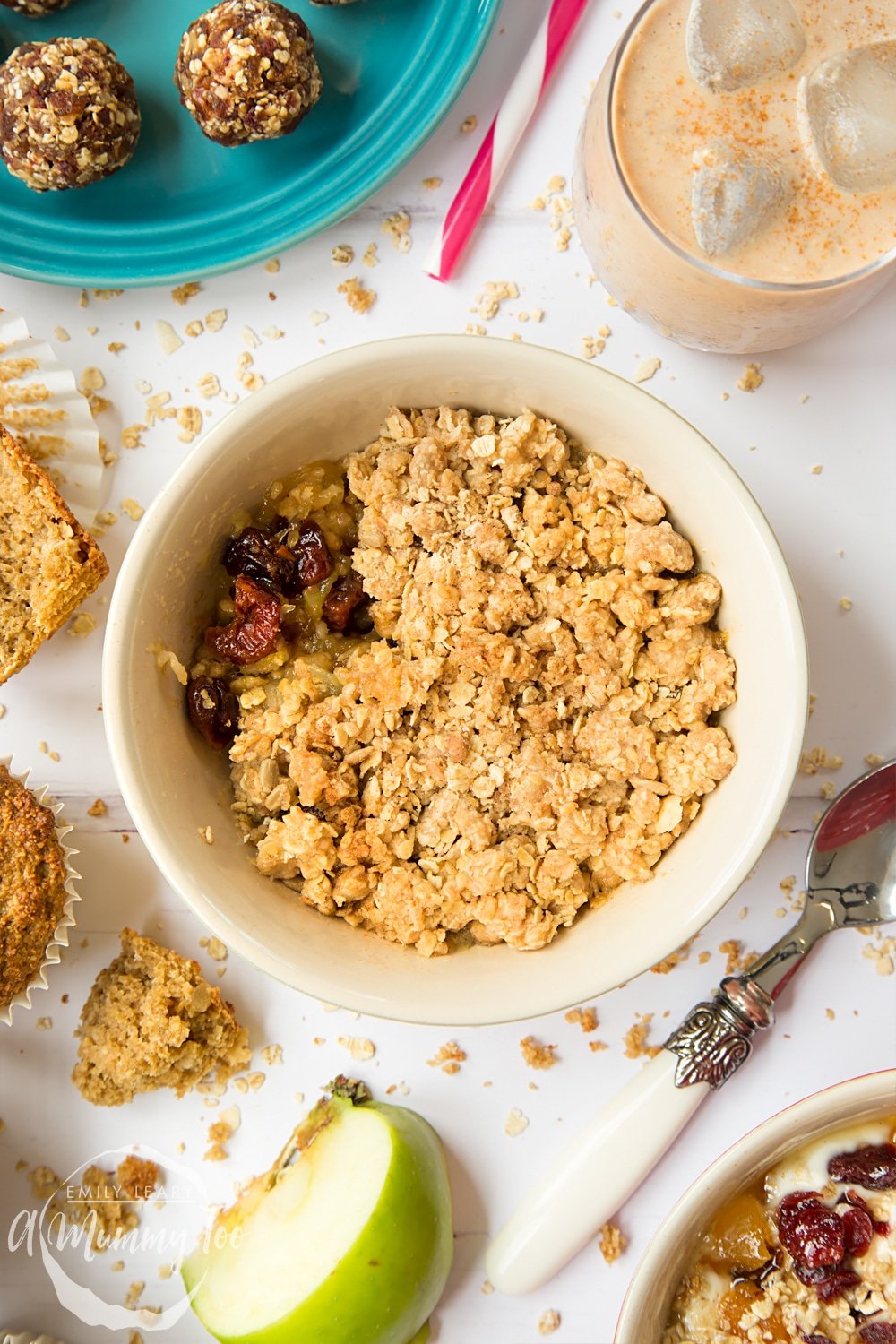 Overhead shot of a bowl of Apple and cherry granola crumble with a decorative spoon on the side.