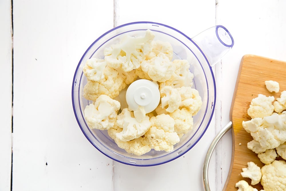 Cauliflower florets shown in a food processor