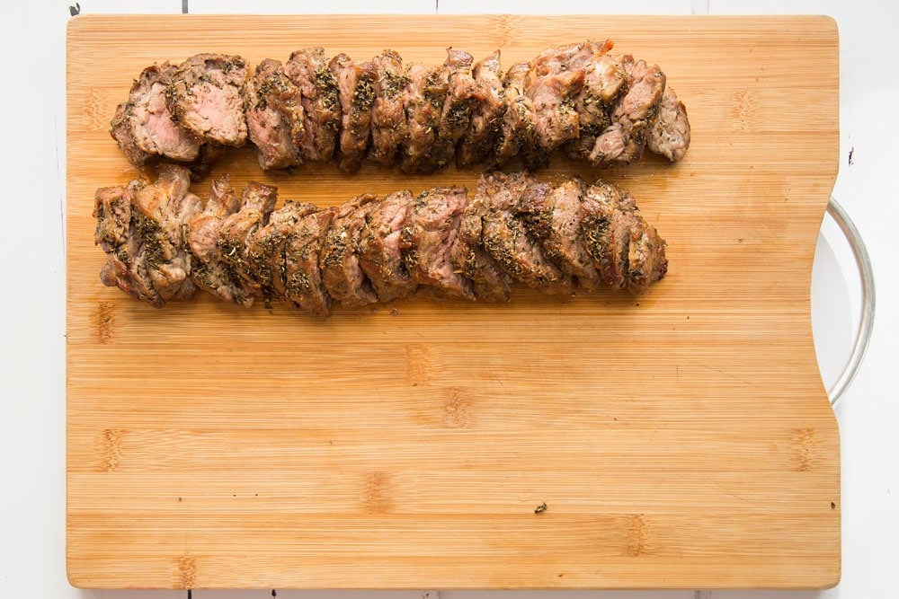 Freshly cooked Welsh lamb, shown on a chopping board ready to assemble into a herb crusted Welsh Lamb in a quick coriander flatbread wrap