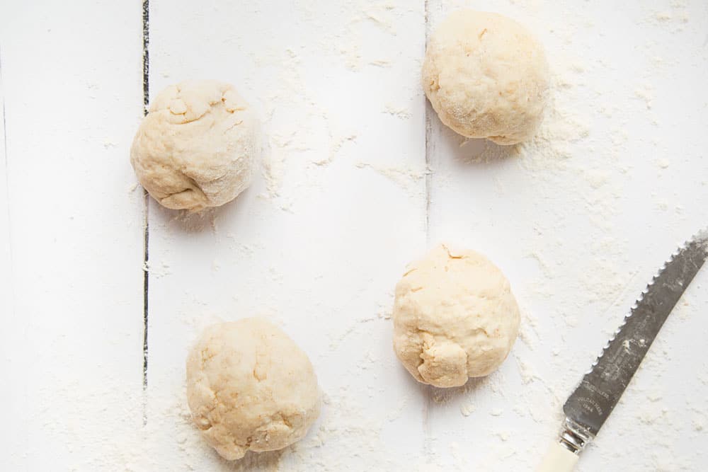 Divide the flatbread dough into four smaller balls of dough