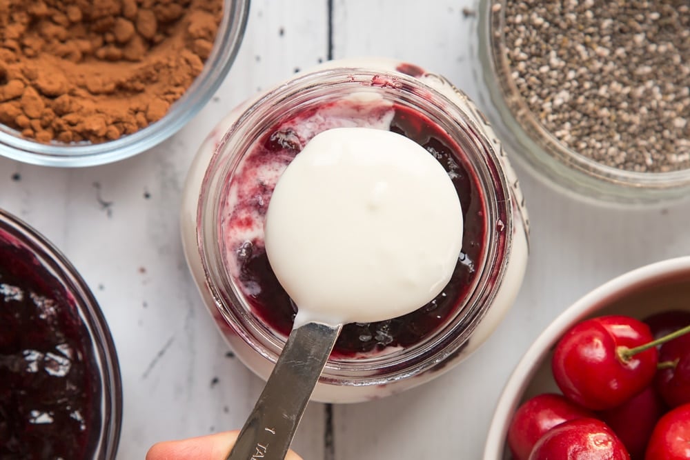 A final layer of yogurt is added to finish the black forest breakfast jar