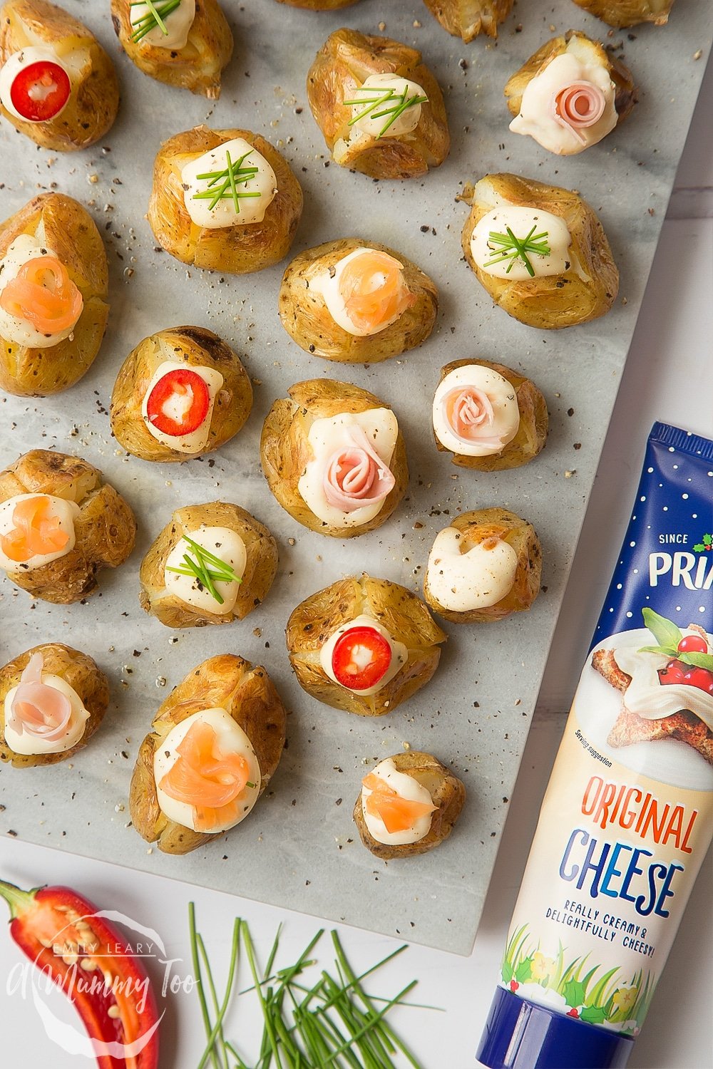 Stuffed mini baked potatoes topped with Primula cheese, peppers, chives, ham and salmon - a delicious festive starter or snack