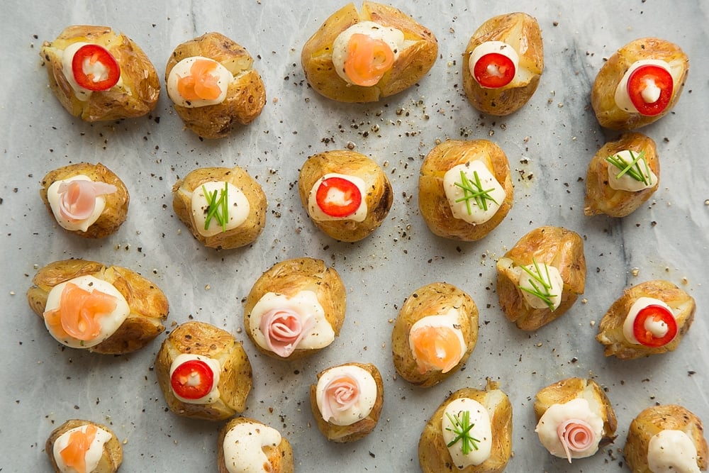 Top the stuffed mini baked potatoes with toppings of your choice - shown here is pepper, chives, salmon and ham