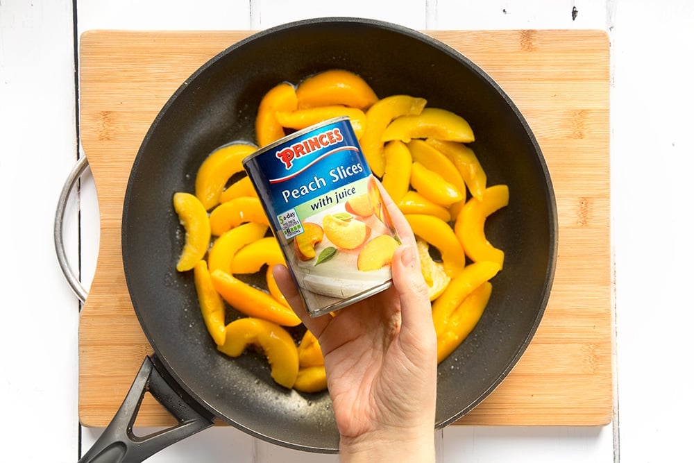 Princes peach slices with juice are added to the frying pan
