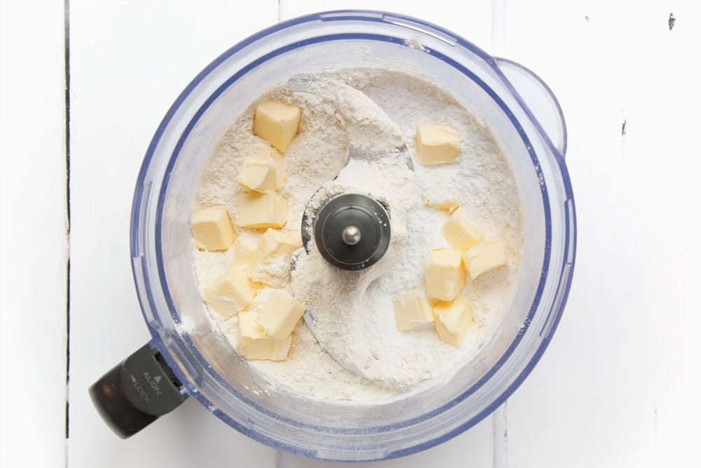 Cubed butter, flour and icing sugar mixed in a bowl