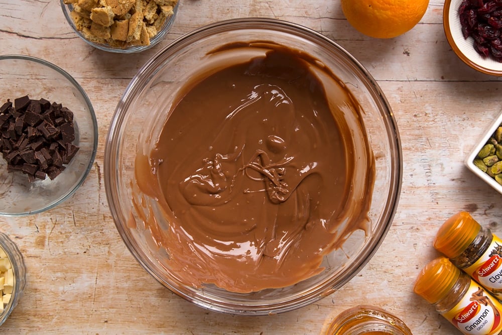Step by step instructions to make Christmas spiced chocolate salami: mixing the melted chocolate and ingredients together