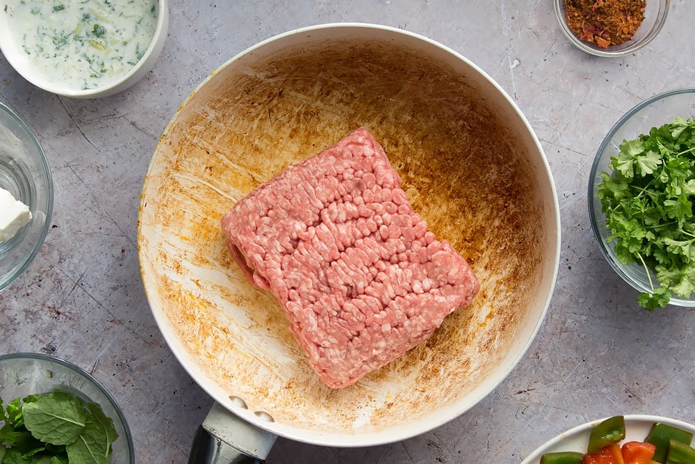 Fresh lamb mince is added to the frying pan