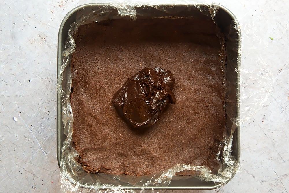 Pouring the topping mixture over the healthier chocolate bars base