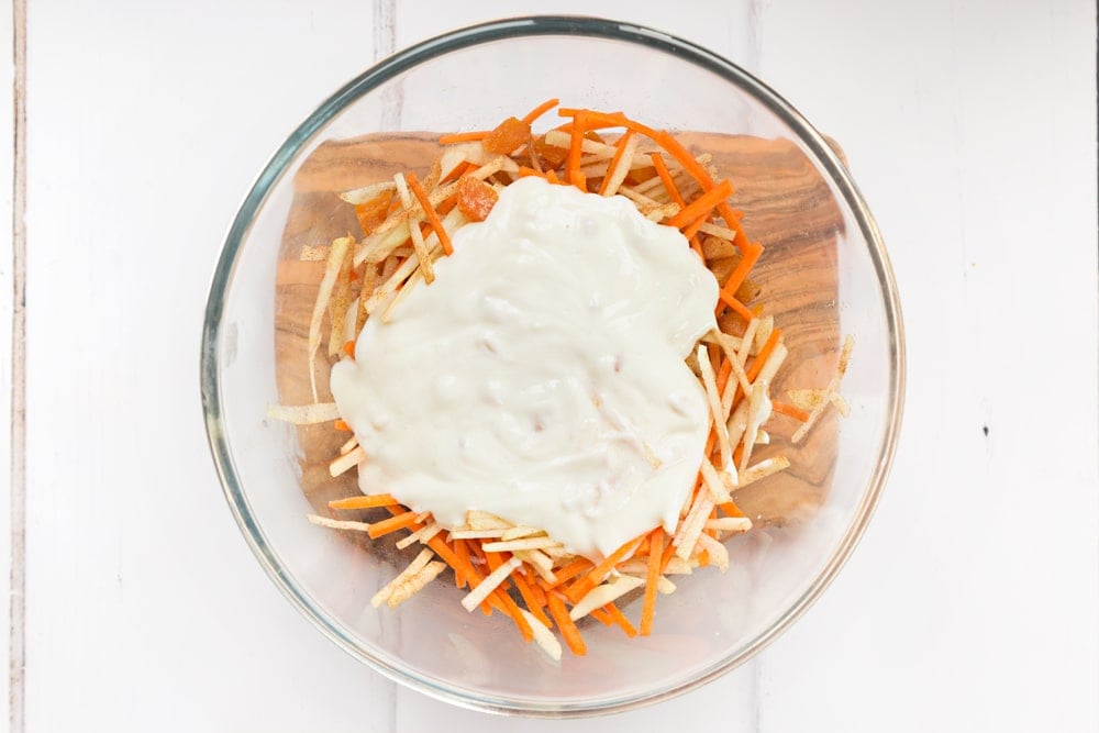 Mixing Onken plain grain yogurt into the sliced fruit and carrot