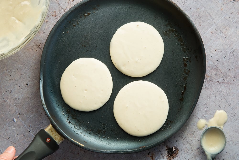 Pancakes shown in a frying pan ready to be cooked