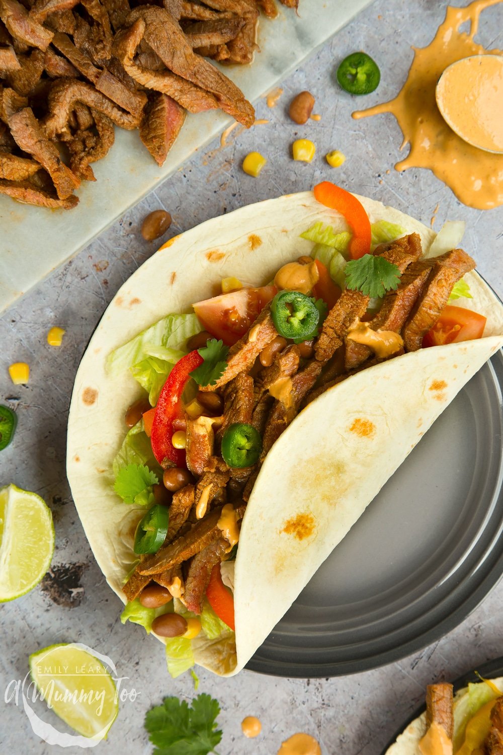 Serve everything to the table, with added accompaniments, for everyone to assemble their own spicy chipotle beef carne asada fajitas!