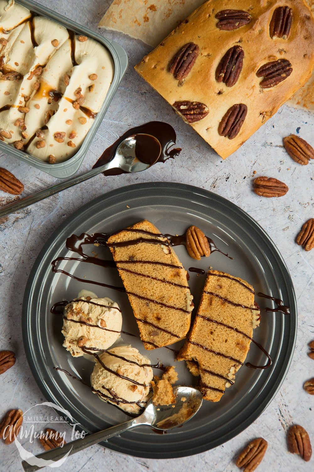 Butterscotch pecan ice cream loaf, pictured sliced and surrounded by ice cream and toppings