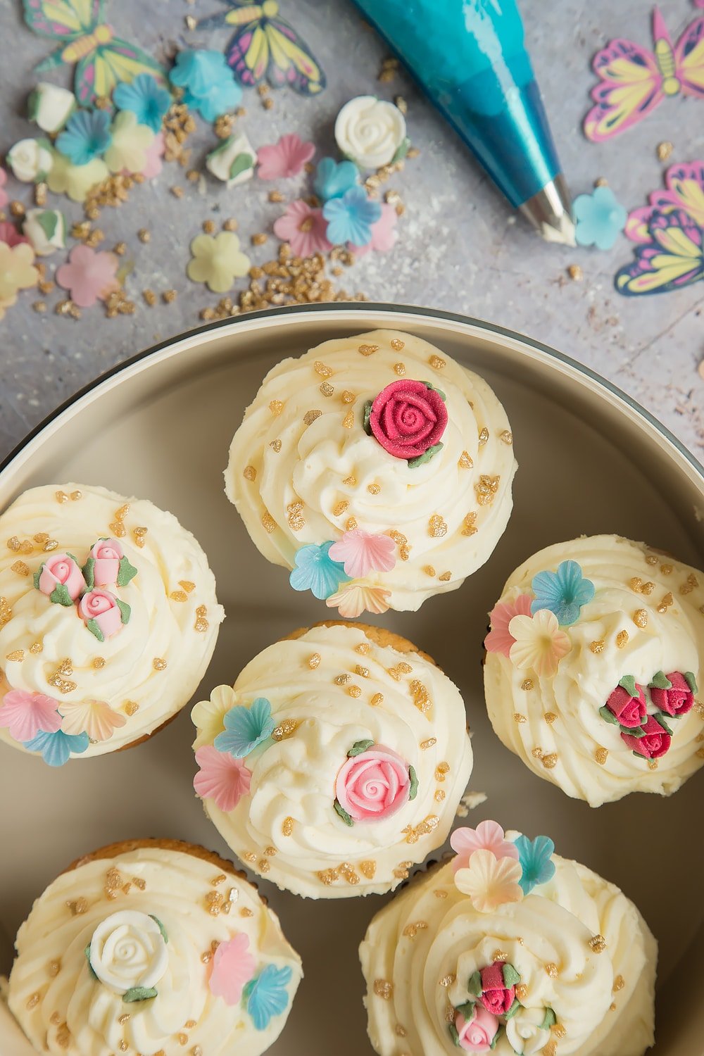 Lemon cupcakes with buttercream frosting, surrounded by decorations