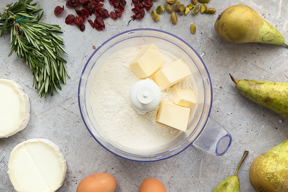 Flour and butter are mixed in a bowl, shown surrounded by goat's cheese, rosemary and pears