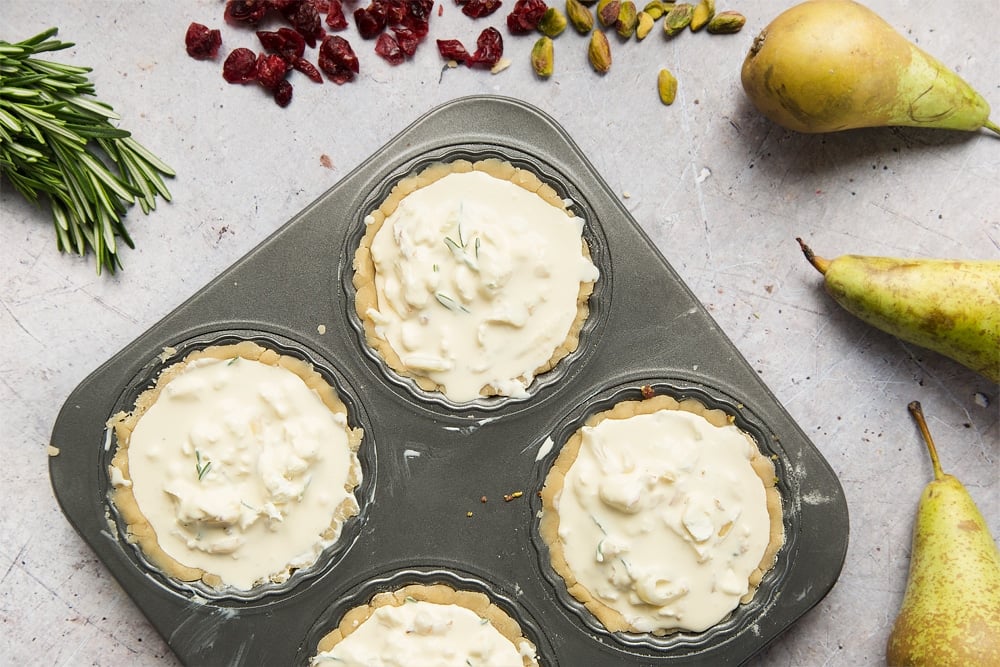 The rosemary, goat's cheese and cream filling is added to the tarts