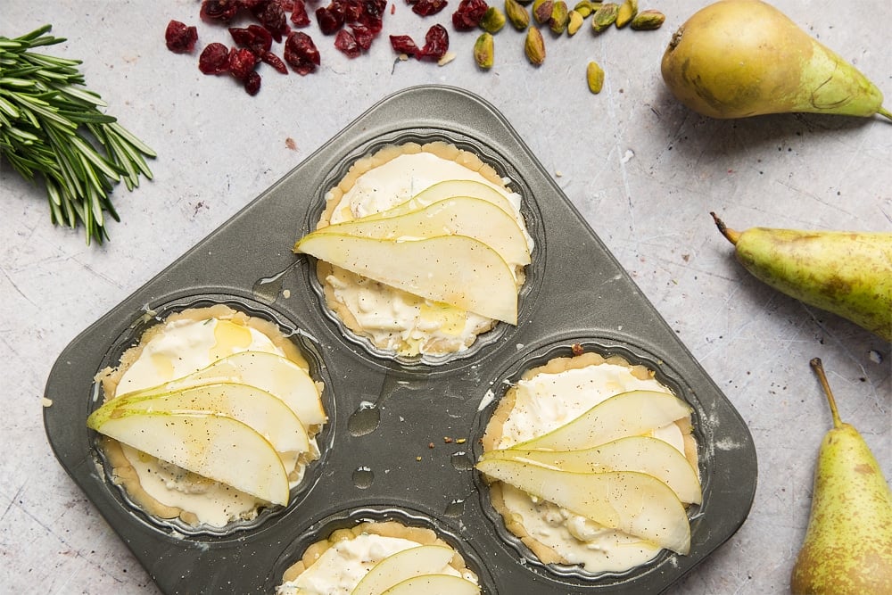 The finished rosemary goat's cheese tarts are topped with sliced pear