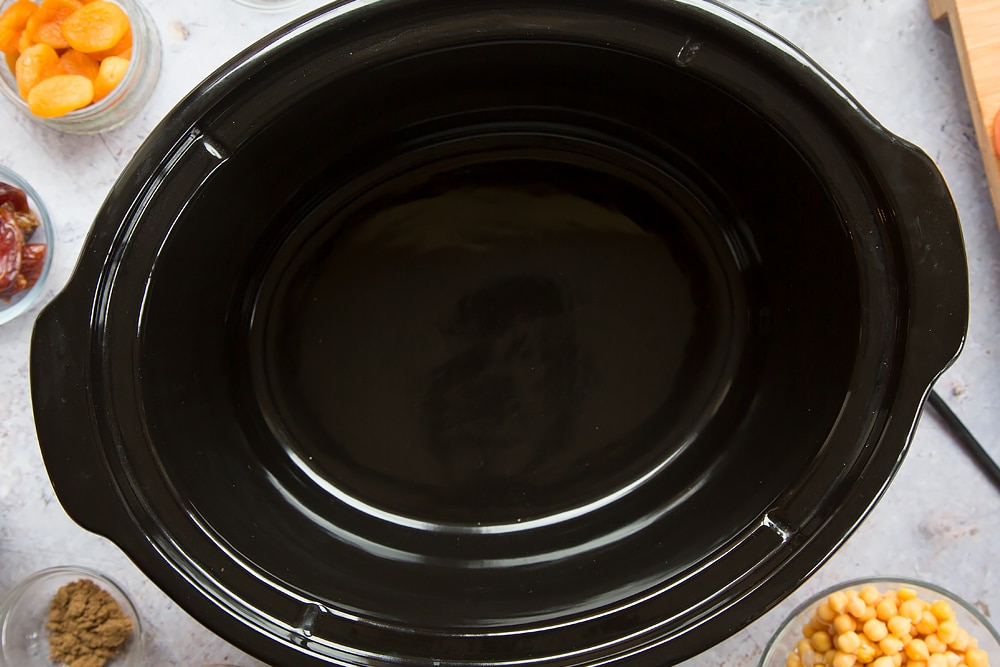 an empty slow cooker black ceramic dish.