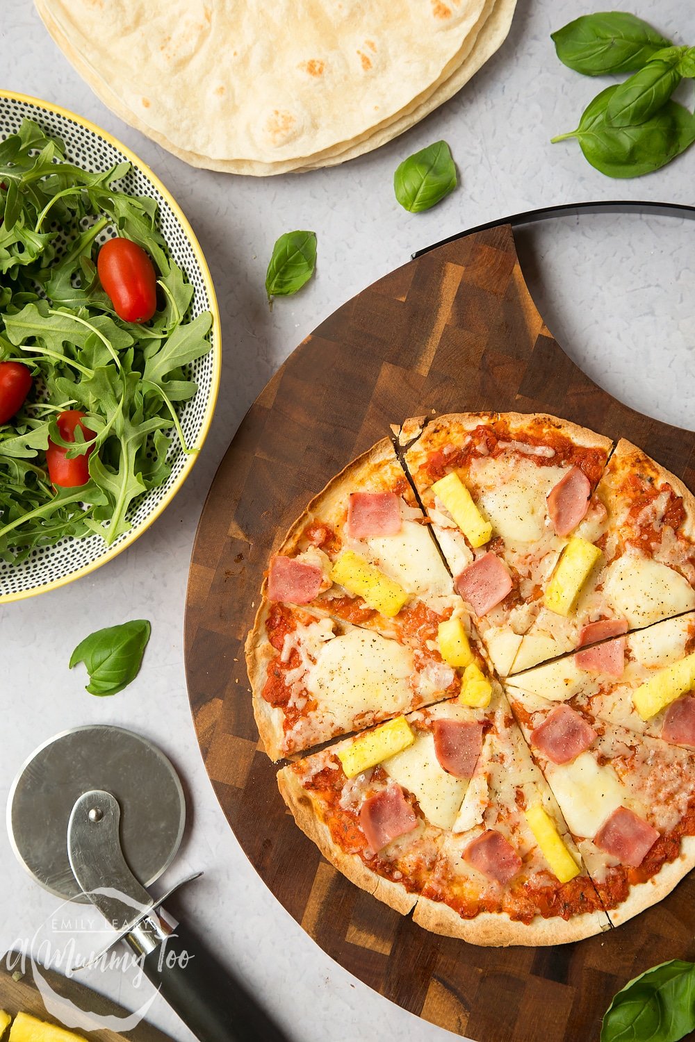 Hawaiian tortilla pizza, cut and ready to serve with salad