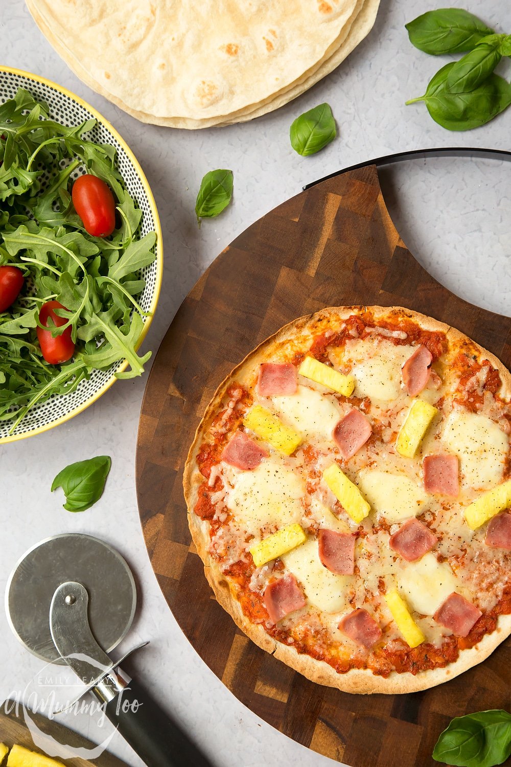 Tasty Hawaiian tortilla pizza, served alongside a salad