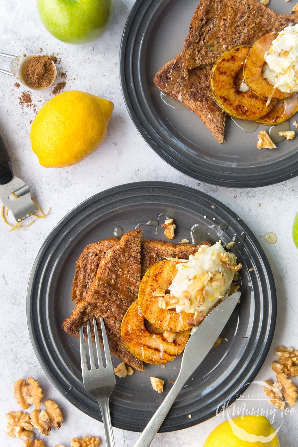 Cinnamon French toast with griddled apple slices and lemon mascarpone on a dark plate surrounded by ingredients.