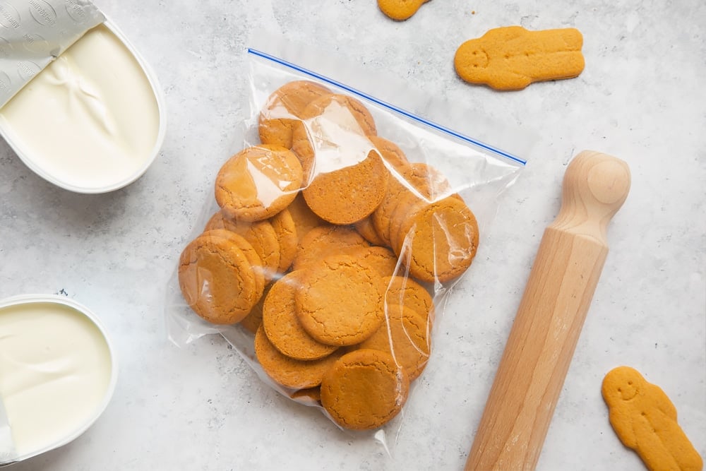 Overhead shot of biscuits inside ziplock bag with a wooden rolling pin on the side