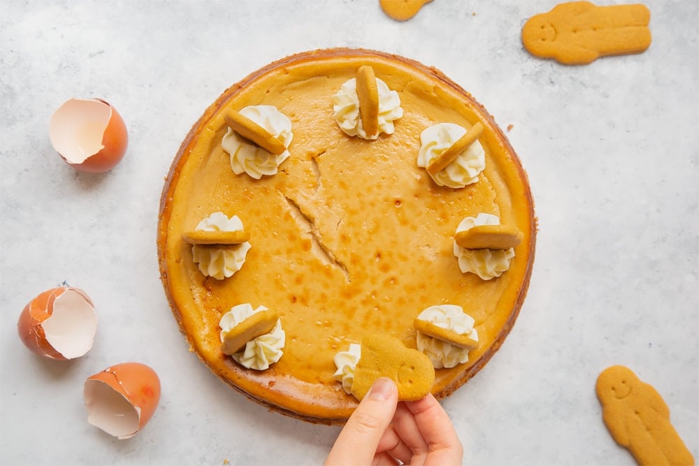 Overhead shot of the gingerbread cheesecake surrounded by cracked eggs and small gingerbread men.