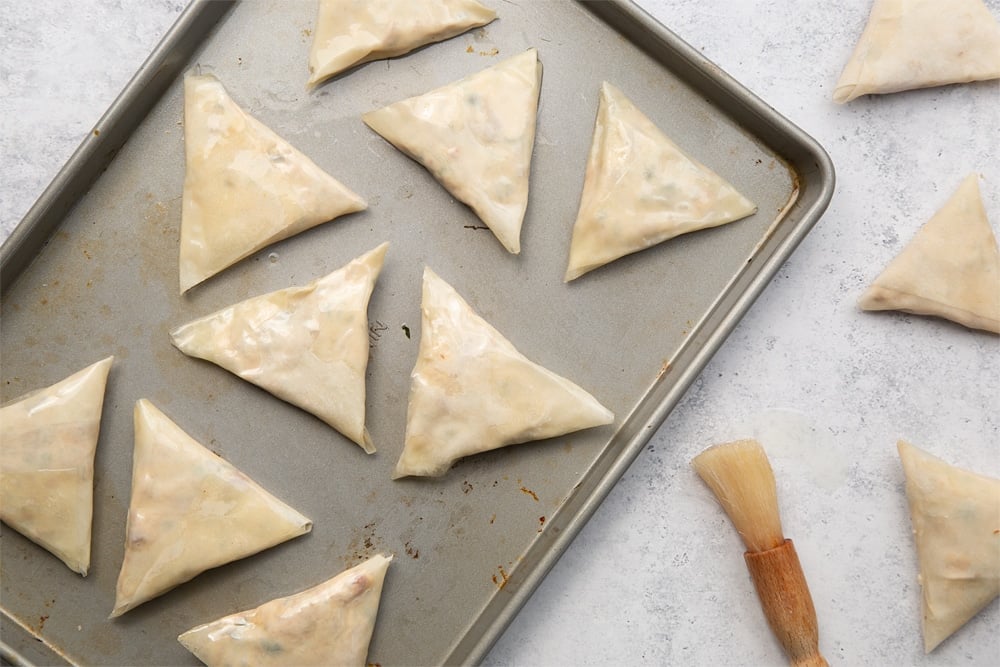 Brush your olive and sun-dried tomato filo parcels with oil and place on a baking tray