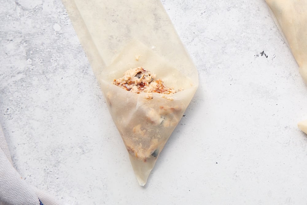 Fill the filo pastry triangle pocket with your ricotta, olive and sun-dried tomato filling